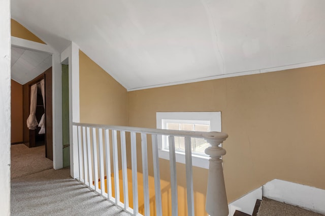 hall with lofted ceiling and carpet floors