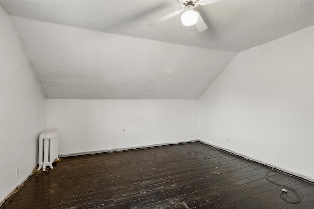 bonus room with ceiling fan, radiator, lofted ceiling, and wood-type flooring