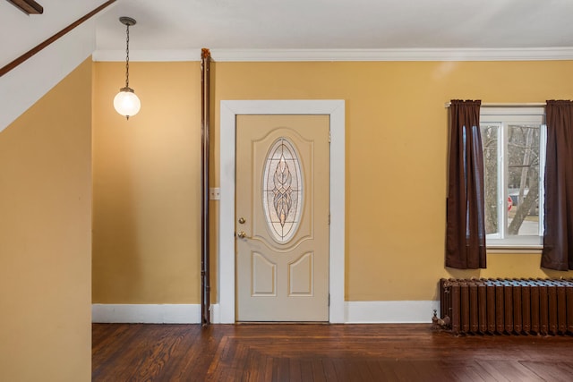 entrance foyer with radiator, baseboards, wood-type flooring, and ornamental molding