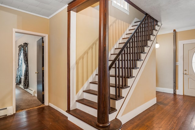 staircase featuring baseboards, baseboard heating, hardwood / wood-style floors, and crown molding