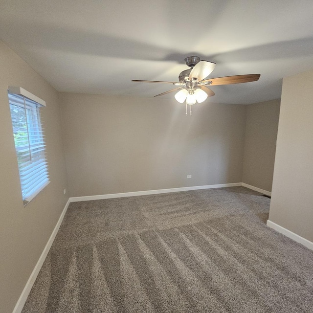 empty room featuring ceiling fan, carpet, and baseboards