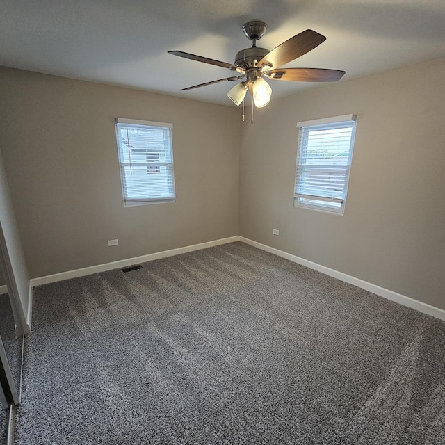 carpeted empty room with a ceiling fan, visible vents, and baseboards