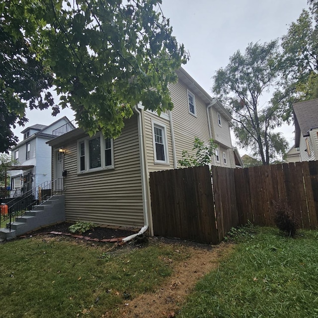 view of side of property with fence and a lawn