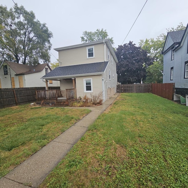 back of property with a lawn and a fenced backyard