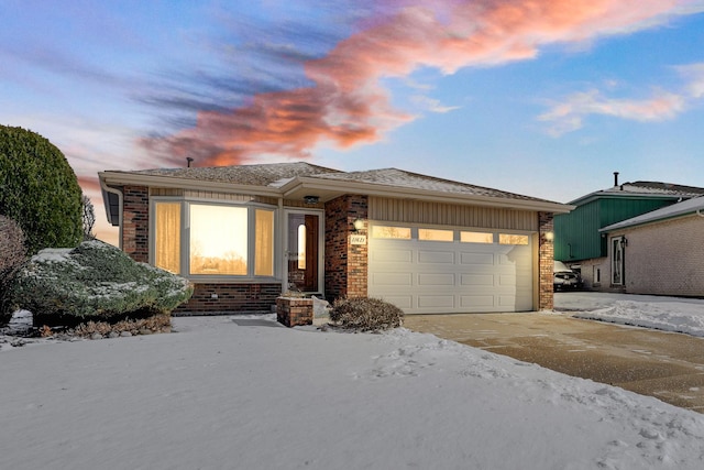 view of front of house with an attached garage, driveway, and brick siding