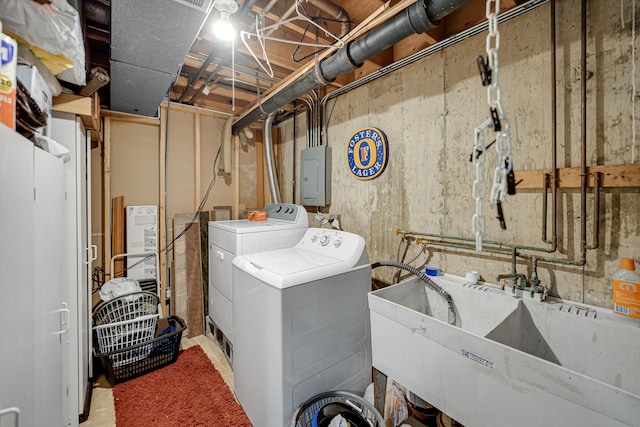 laundry area featuring laundry area, washer and clothes dryer, a sink, and electric panel