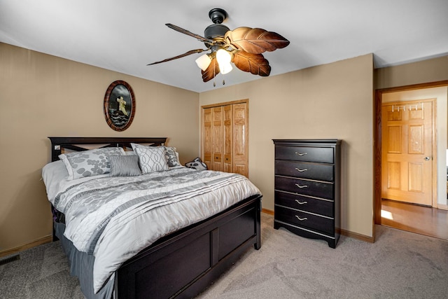 bedroom with a closet, visible vents, light carpet, ceiling fan, and baseboards