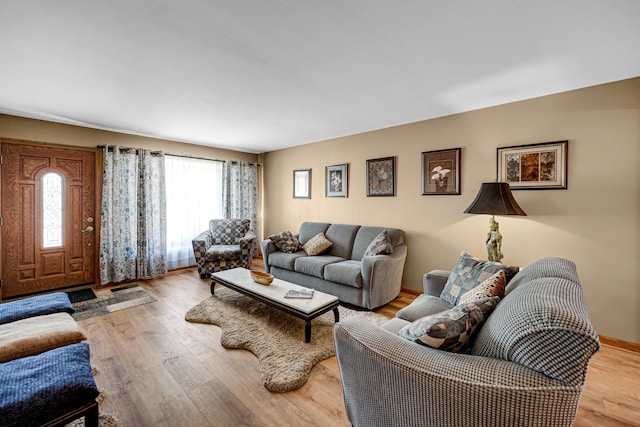 living area with light wood-type flooring and baseboards