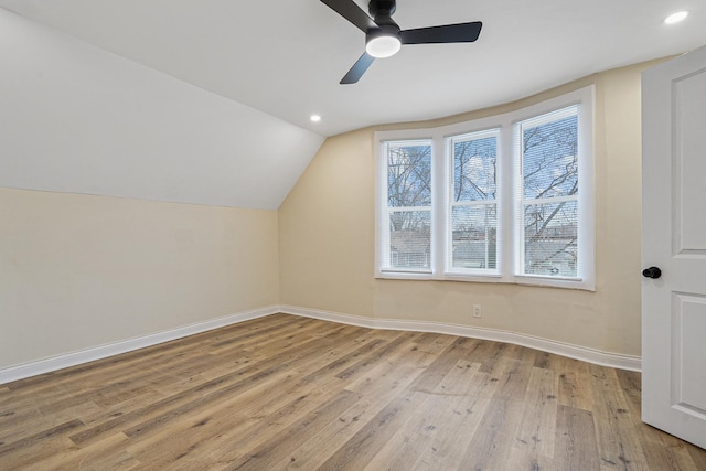 additional living space with light wood-type flooring, baseboards, vaulted ceiling, and recessed lighting