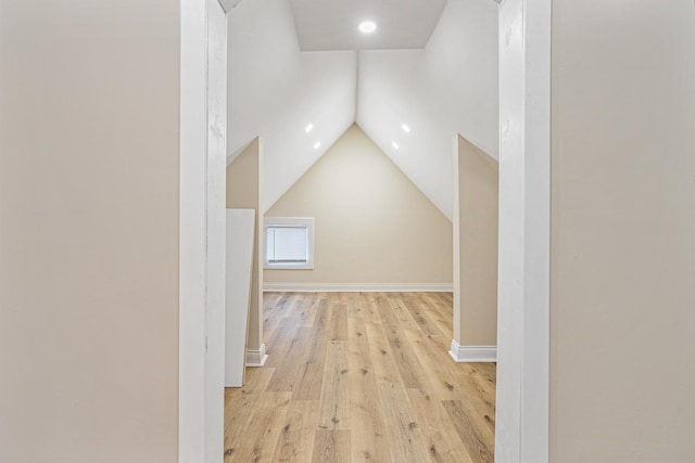 additional living space with vaulted ceiling, wood-type flooring, and baseboards