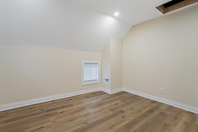 additional living space with lofted ceiling, recessed lighting, visible vents, wood finished floors, and baseboards