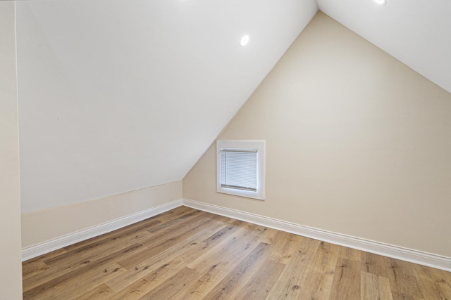 additional living space with vaulted ceiling, hardwood / wood-style floors, recessed lighting, and baseboards