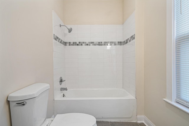 bathroom with tile patterned flooring, bathtub / shower combination, baseboards, and toilet