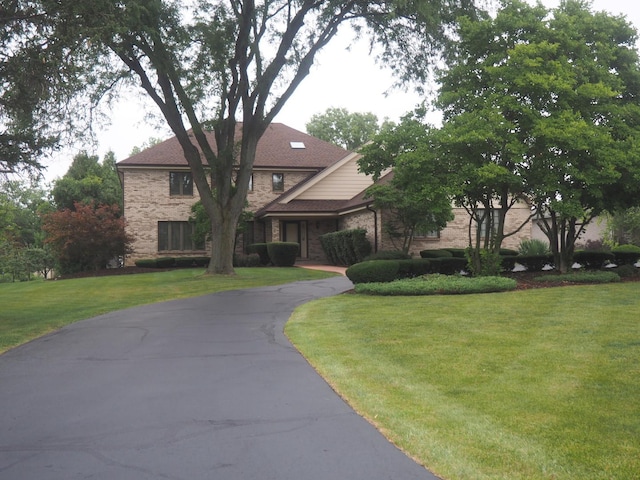 view of front facade with brick siding and a front yard