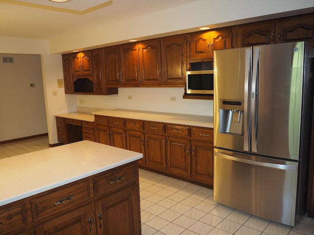 kitchen featuring light tile patterned floors, stainless steel appliances, light countertops, and visible vents