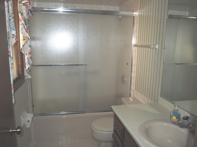 full bathroom featuring enclosed tub / shower combo, vanity, and toilet