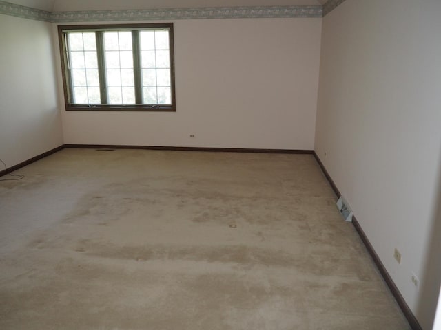 spare room featuring light carpet, visible vents, and baseboards