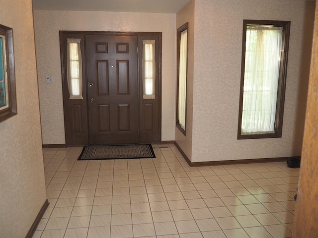 entryway featuring light tile patterned floors, baseboards, and wallpapered walls