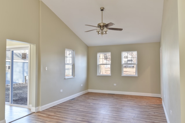 empty room with baseboards, wood finished floors, a ceiling fan, and vaulted ceiling