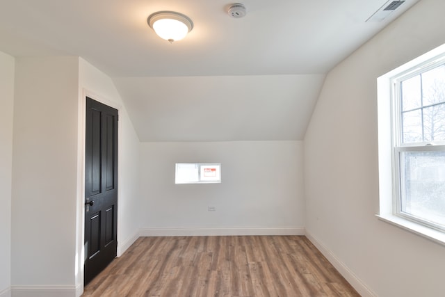 bonus room featuring baseboards, lofted ceiling, and wood finished floors