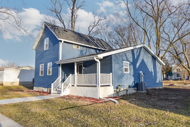 traditional-style house with a porch, central AC unit, and a front yard