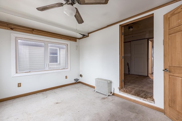 empty room featuring carpet floors, radiator heating unit, a ceiling fan, and baseboards