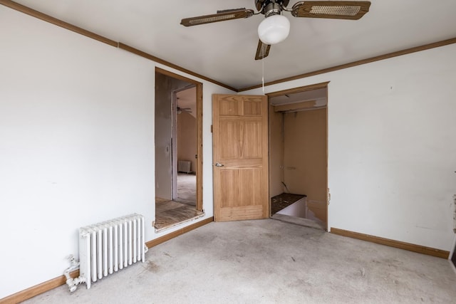 spare room with carpet, radiator, radiator heating unit, ornamental molding, and baseboards