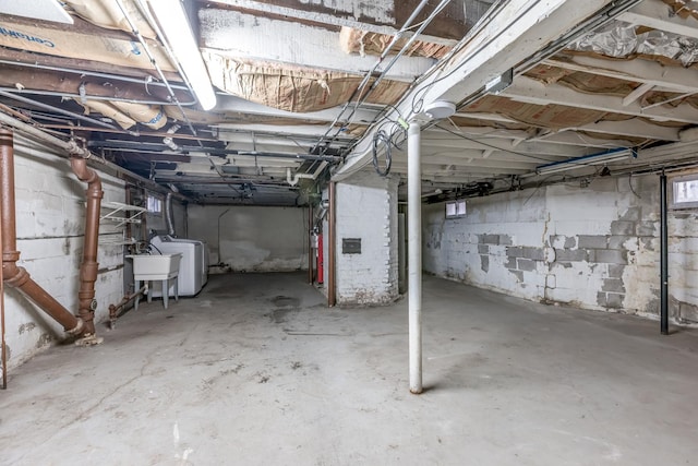 unfinished basement featuring washer / dryer and a sink