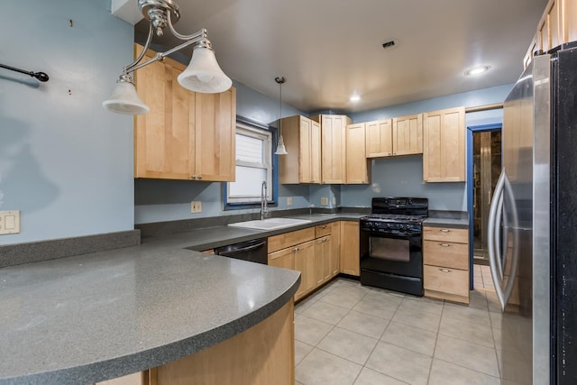 kitchen with black gas stove, light brown cabinetry, a sink, and freestanding refrigerator