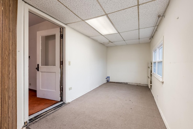 spare room with baseboards, carpet flooring, and a drop ceiling