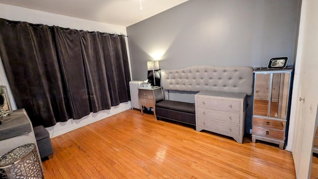 bedroom featuring hardwood / wood-style flooring and radiator