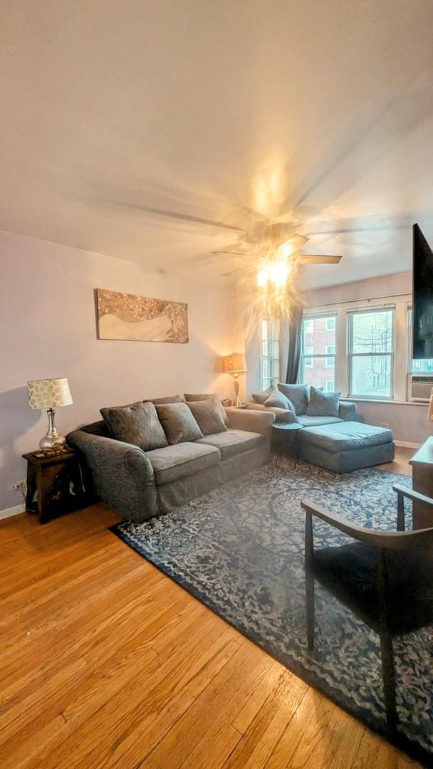 living area with ceiling fan, baseboards, and wood finished floors