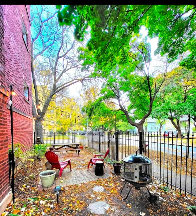 view of yard with a patio area, fence, and a fire pit