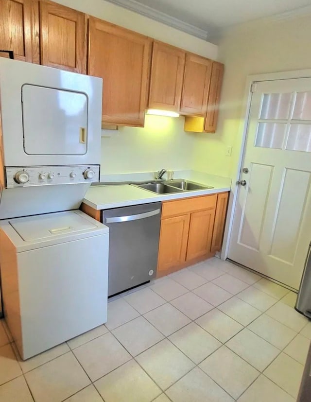 kitchen with stacked washer / dryer, a sink, light countertops, and stainless steel dishwasher