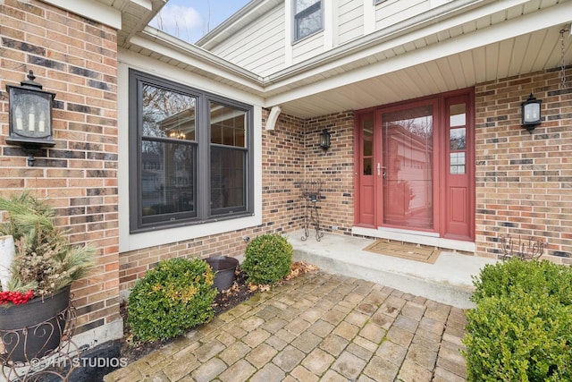 doorway to property featuring brick siding