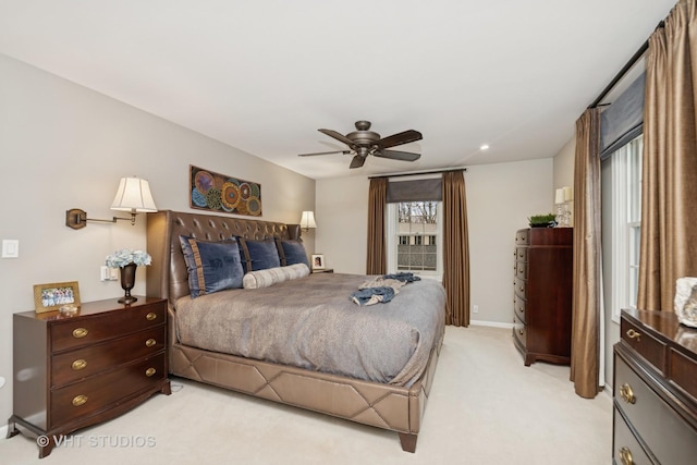 bedroom with a ceiling fan, light carpet, and baseboards