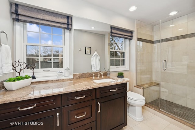 full bath featuring a stall shower, toilet, tile patterned floors, vanity, and recessed lighting