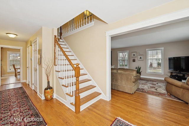 staircase with baseboards and wood finished floors