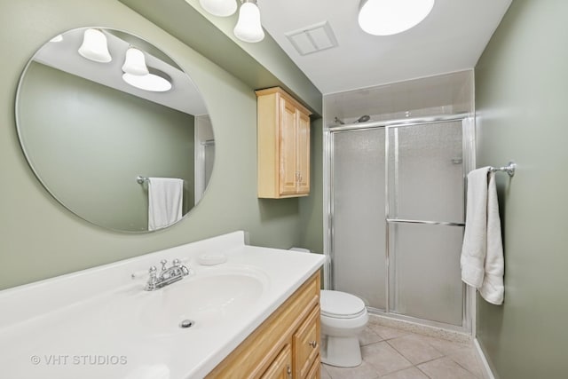 bathroom featuring toilet, a shower stall, vanity, and tile patterned floors