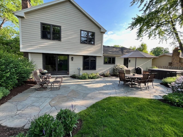 back of house featuring entry steps, a patio area, and a hot tub