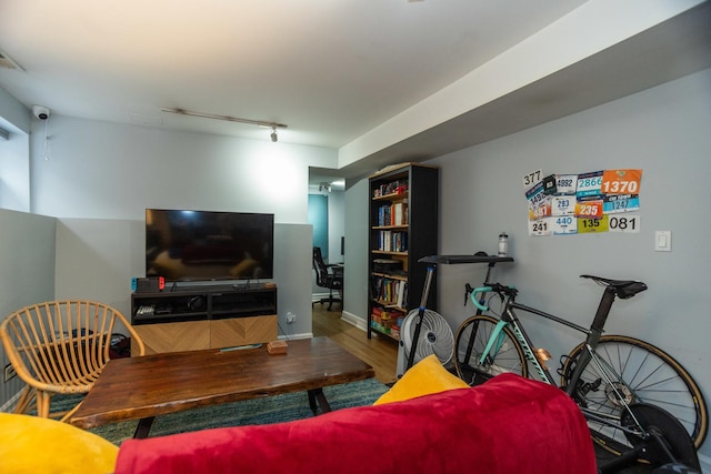 living room with track lighting and wood finished floors