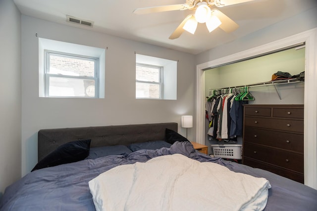 bedroom with visible vents, multiple windows, a closet, and a ceiling fan