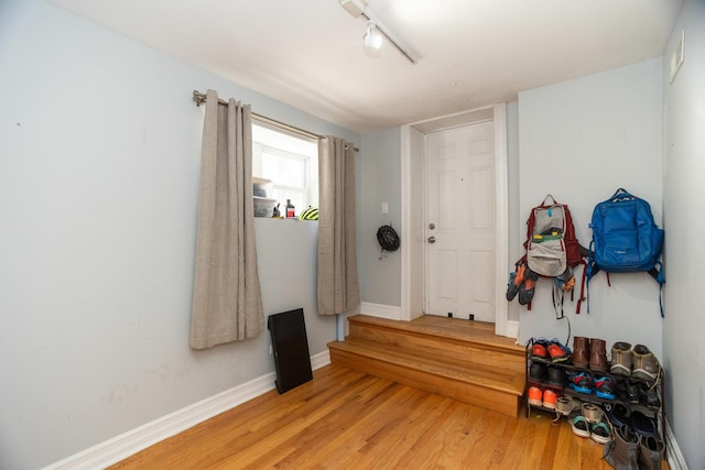 foyer with track lighting, light wood-style flooring, and baseboards