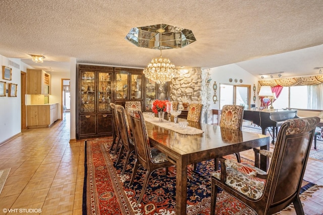 dining area featuring lofted ceiling, a notable chandelier, visible vents, and a textured ceiling