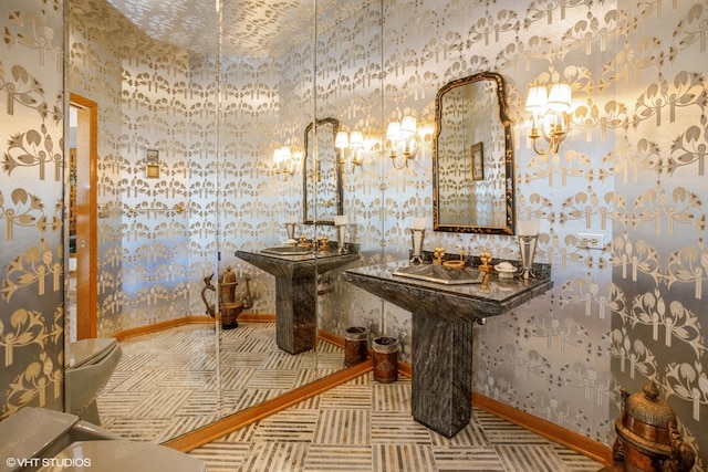 bathroom with wallpapered walls and baseboards