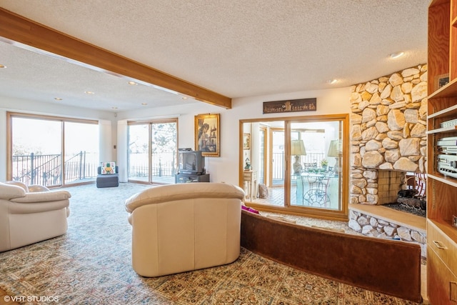 carpeted living area featuring a stone fireplace, beam ceiling, and a textured ceiling