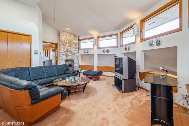 carpeted living area featuring a stone fireplace, baseboards, and high vaulted ceiling