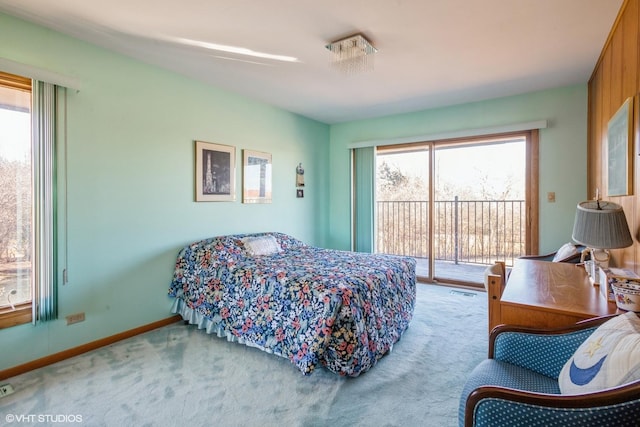 carpeted bedroom with access to exterior and baseboards