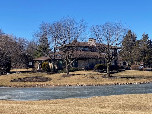 view of front of home with a water view and a chimney