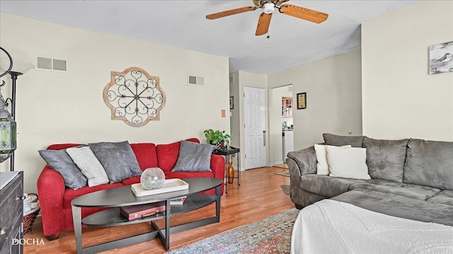 living room with ceiling fan, visible vents, and wood finished floors